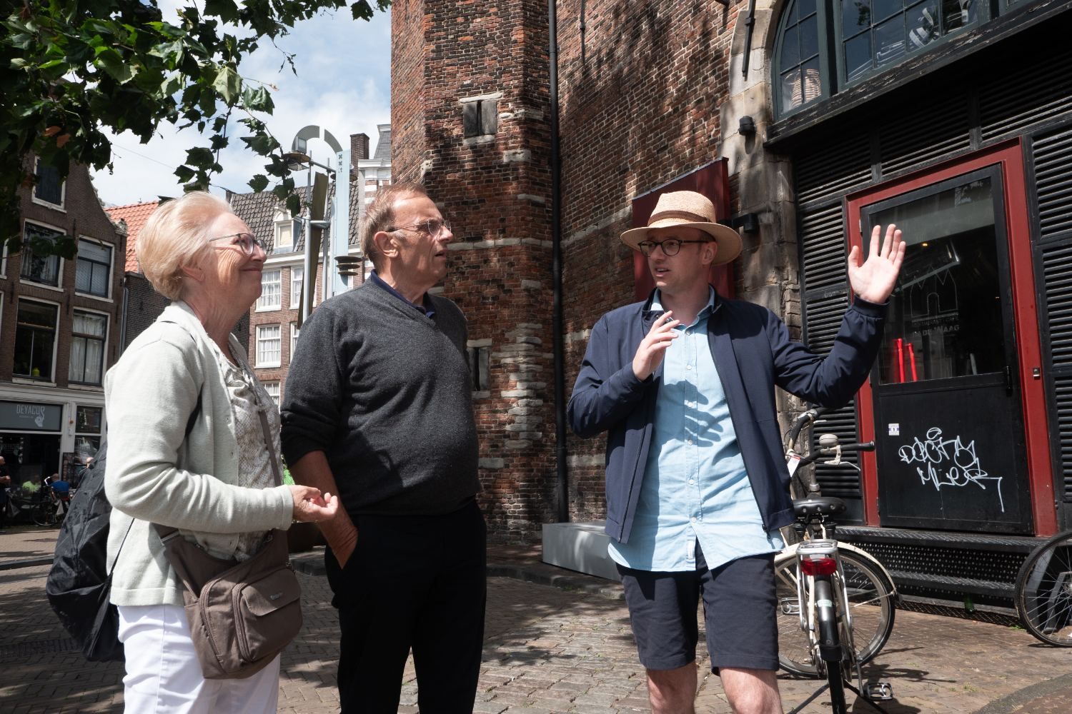 Jan telling a story beside a medieval brick church in Amsterdam's old centre