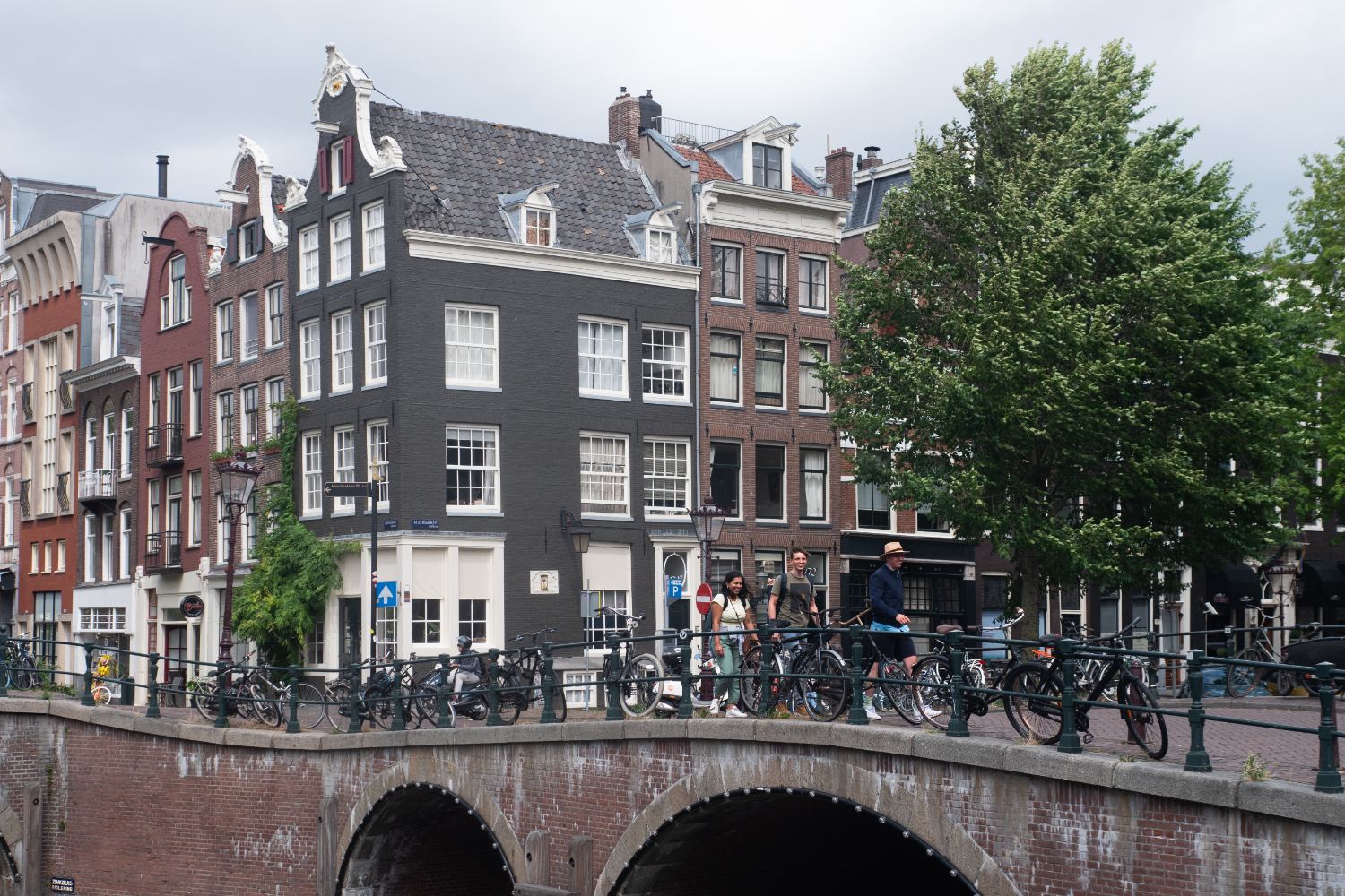 Bicycles on a canal bridge in Amsterdam, with gabled merchant houses behind