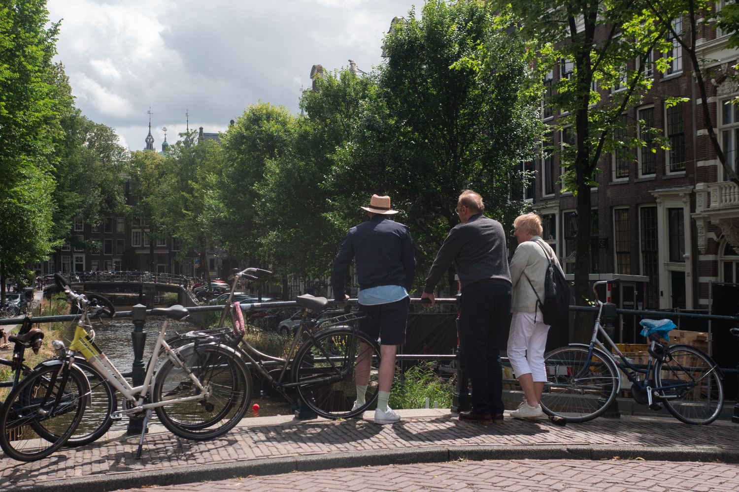 Guests pausing on a canal bridge to look out over the water in Amsterdam